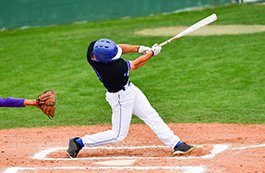 young man swinging baseball bat